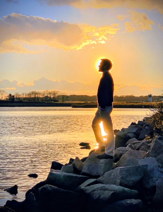 Noah B. Price standing by water at sunset